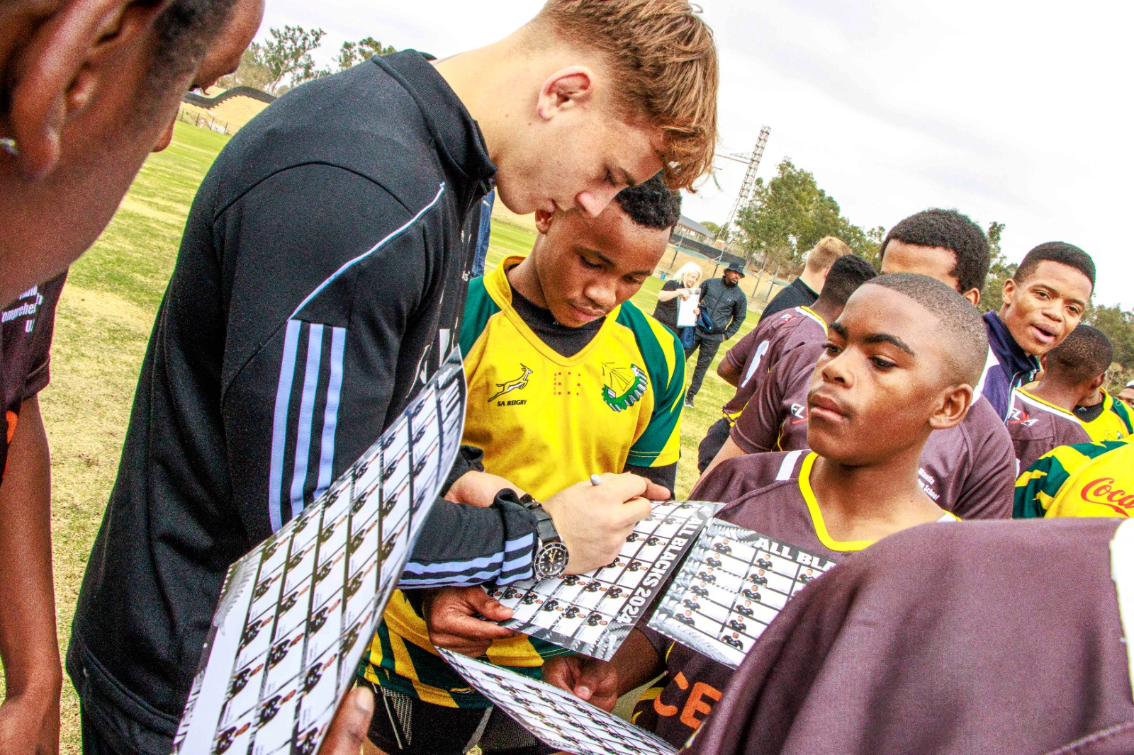 All Blacks player signs autograph for excited child