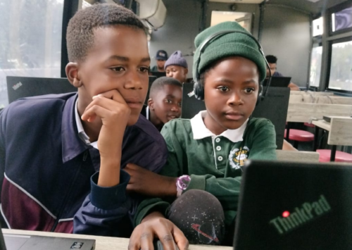 Two children work at their laptops