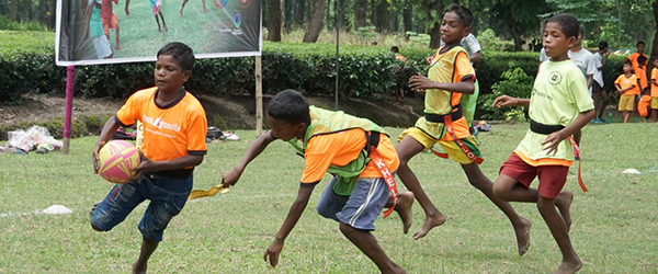 Children with no shoes play rugby